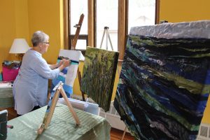 Pam Collins creating art in her home studio.